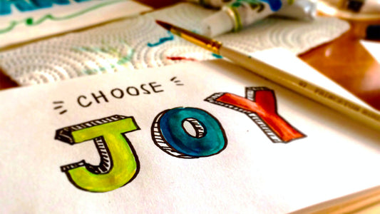 Het woord "Joy" getekend op een blaadje